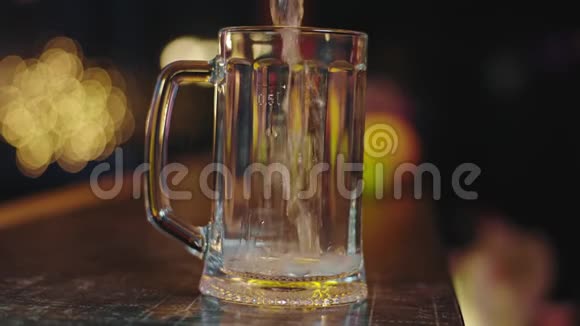 在镜头前的特写镜头中一杯冰镇啤酒倒入一杯啤酒中会产生气泡视频的预览图