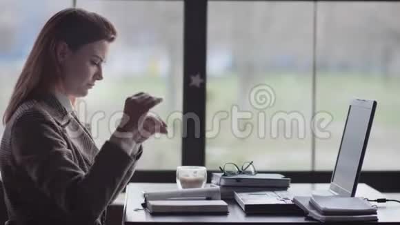 一个疲惫的女孩的肖像一个商务女性因为努力工作而紧张坐在靠窗的桌子上视频的预览图