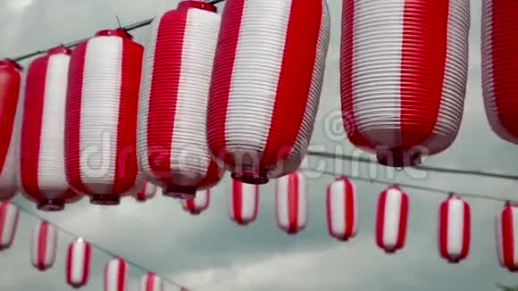 许多东方纸红白灯笼楚钦挂在白色多云的蓝天背景上日本挂的灯笼视频的预览图