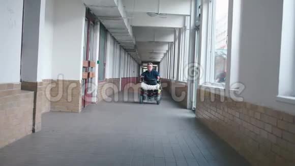 一个坐轮椅的女人正沿着一条长长的走廊开车视频的预览图