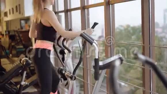 那个女孩带着模拟器在外面工作看着健身房的窗户视频的预览图