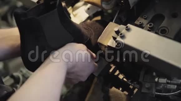 男人用特殊的机床做鞋子一家鞋厂的传送带上有鞋和鞋底大规模生产视频的预览图