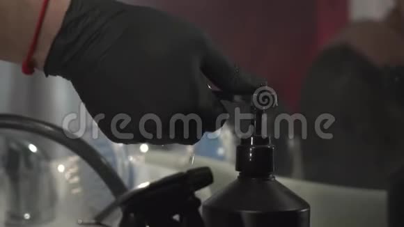 戴着黑色手套和红色T恤的理发师拿着洗发水给他的客户洗头视频的预览图