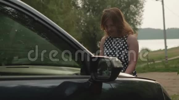 穿斑点衣服的女孩打开汽车引擎盖进行汽车修理视频的预览图
