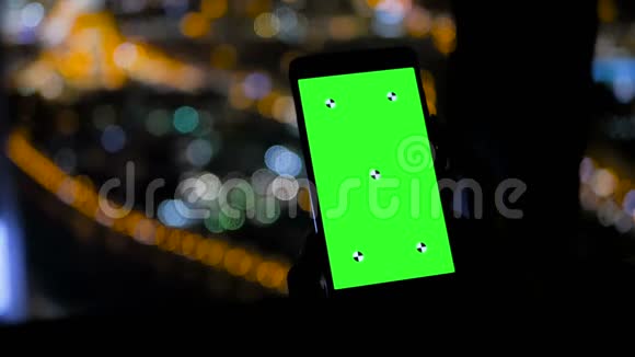 夜间使用垂直黑色智能手机的贴身女性视频的预览图