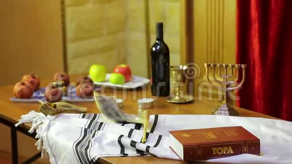 会堂的桌子上摆着罗什哈珊的象征塔利斯和蜡烛旁边的款待和舍法拉视频的预览图