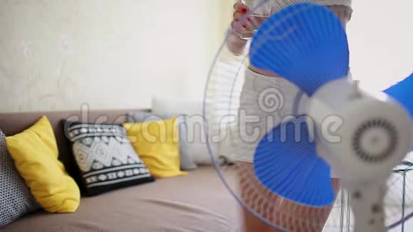 年轻女子打开呼吸机在家里喝水降温夏日炎炎视频的预览图