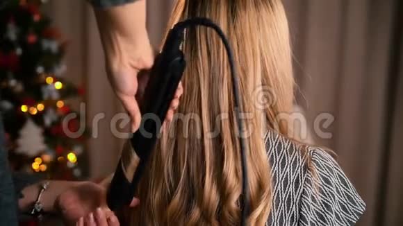 未被识别的化妆师用理发器和发钳抚平和收紧头发在内部视频的预览图