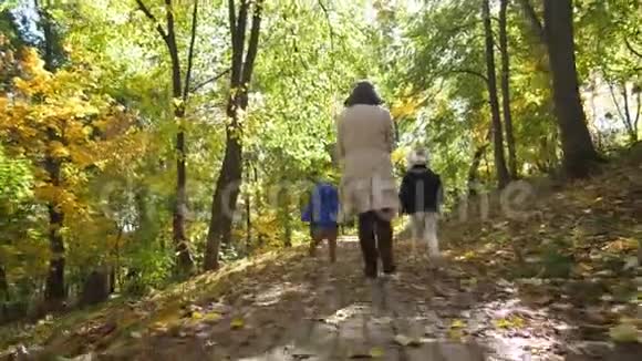 充满欢乐的妈妈带着孩子跑过公园视频的预览图