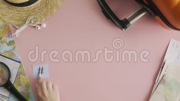 顶部的双手躺在粉红色的书桌上视频的预览图