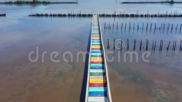 泰国的彩虹桥在泰国萨穆特萨洪省五颜六色的木桥延伸到蓝天下的大海视频的预览图