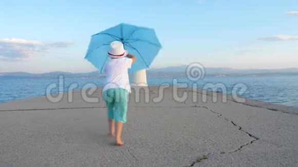 在灯塔附近的码头上和翁贝拉玩耍的年轻旅行者欧洲和孩子一起旅行家庭度假背景希腊是视频的预览图