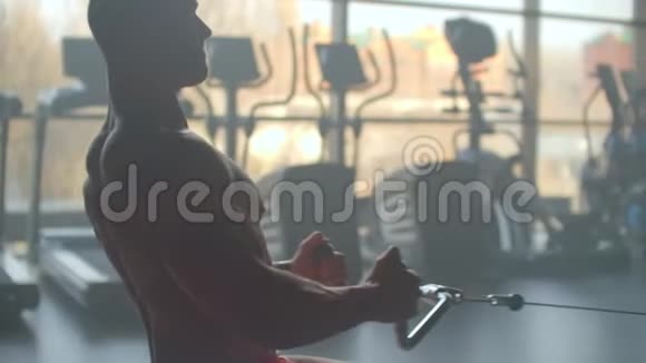 运动员在模拟器里做举重练习把酒吧拉到一个大窗户健身房的背景上视频的预览图