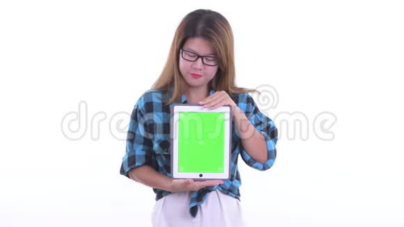 一位年轻的亚洲潮女一边说一边展示数码平板电脑视频的预览图