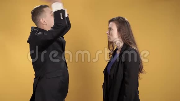 年轻夫妇在黄色的背景上咒骂和打手势视频的预览图