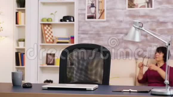 坐在桌子上的老人打开手提电脑开始工作视频的预览图