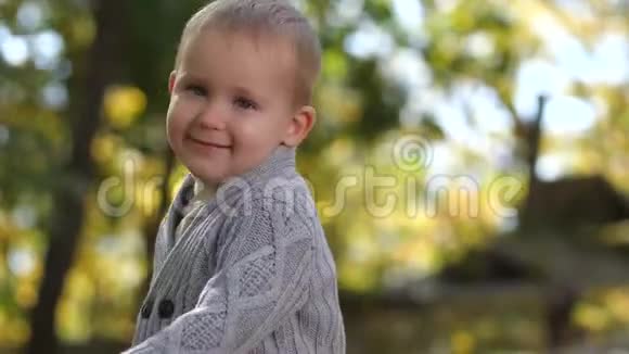 可爱害羞的男孩在室外镜头前微笑的肖像视频的预览图
