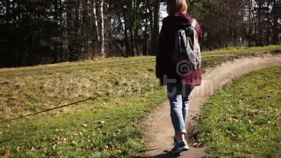 一个女孩在村里的一条路上遛狗的后景和狗一起走视频的预览图