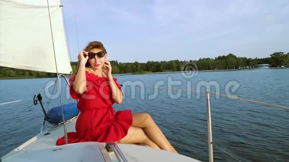 在帆船上的水上旅行中迷人的女孩看着摄像机视频的预览图