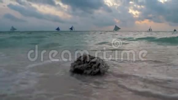 令人惊叹的热带日落帆船的轮廓漂浮在海洋地平线上海浪洗沙Borac视频的预览图