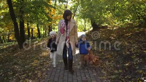 快乐的妈妈和小孩沿着公园小路散步视频的预览图