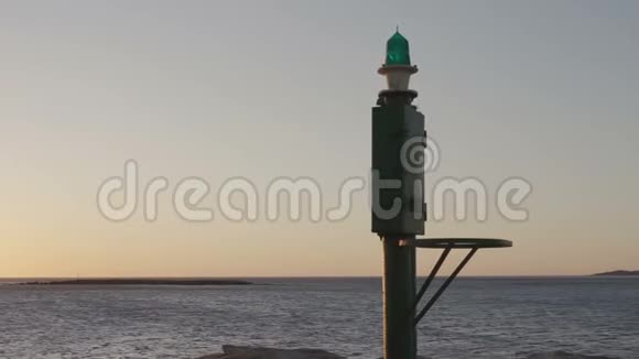 日出或日落时海面的全景画面前景是港口的小灯塔视频的预览图