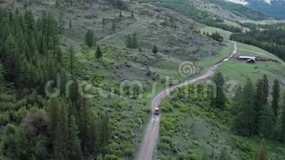 卡车沿着乡村公路行驶走出树林经过村庄4k视频的预览图