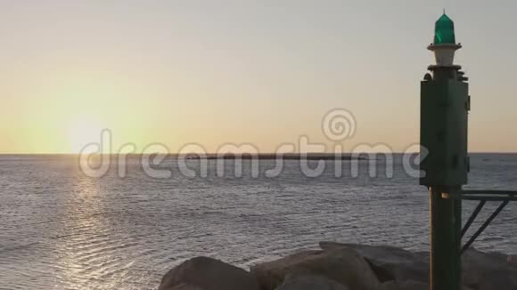 日出或日落时大海的全景图在港口的一个小灯塔在前景中视频的预览图