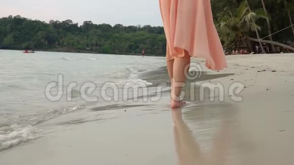 年轻女子在沙滩上赤脚行走的慢动作腿视频的预览图