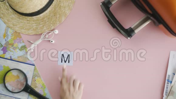 顶部的双手躺在粉红色的桌子上上面写着米兰视频的预览图