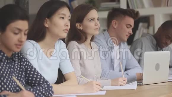 混合种族的队友坐在教育讲座上视频的预览图