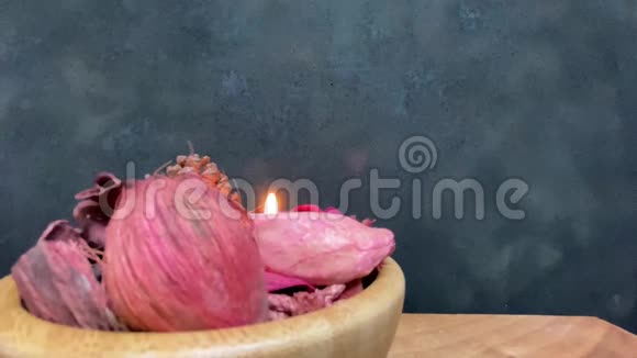 紫色的茶光和干壶放在木碗里放在黑色背景的桌子上视频的预览图