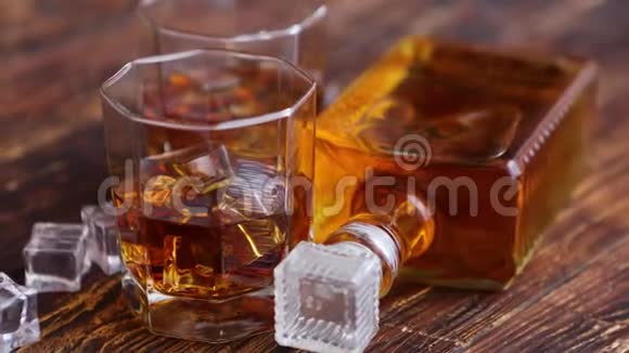 一瓶威士忌两杯放在乡村木桌上视频的预览图