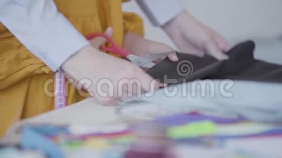 一位母亲的特写双手帮女儿剪了一块漂亮的布料裁缝在家工作快乐视频的预览图