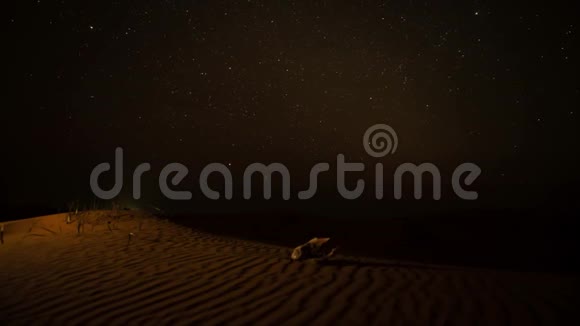 随着时间推移旋转落下的星星围绕着沙漠中的沙丘上的头骨视频的预览图