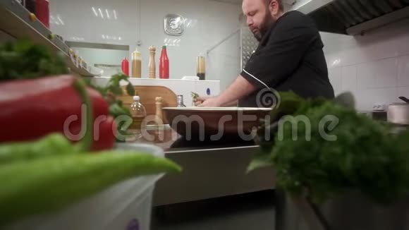 一个丰满的厨师在蔬菜中加入串豆然后把它们混合在炒锅里视频的预览图