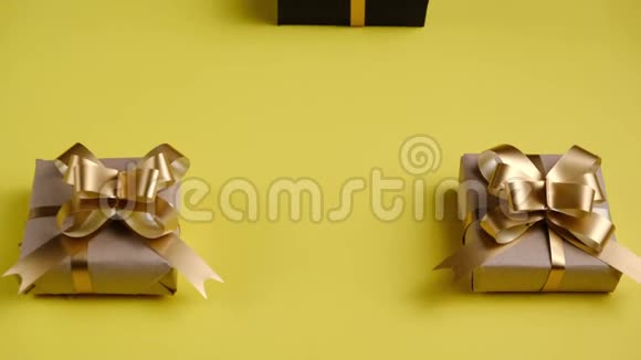儿童的双手将礼品盒贴在黄色背景上圣诞节新年生日概念视频的预览图