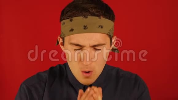 一个戴着绷带的男人打哈欠用红色的背景揉眼睛视频的预览图