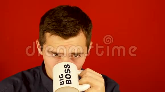 一个男人从一个杯子里喝上面写着红色背景下的大老板视频的预览图