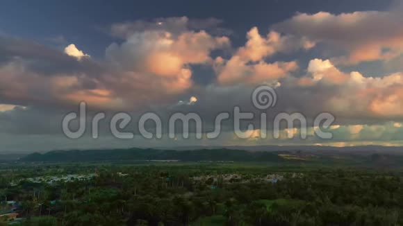 太阳落山时Drone在热带景观上突然升起上面有粉红色的蓬松云视频的预览图