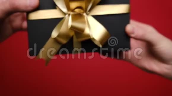 双手POV在红色背景上赠送手工礼品盒圣诞节情人节和生日概念视频的预览图