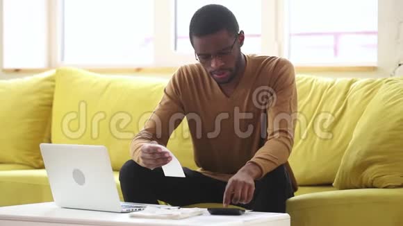严肃的非裔美国人用计算器计算家庭账单视频的预览图