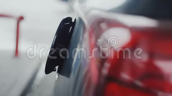 在打开蓝色现代汽车燃油帽盖子的特写镜头上男子正在加油站用喷嘴为他的车辆加油视频的预览图