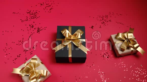 女性手拿着各种礼品盒红色背景上有纸屑圣诞节情人节和生日概念视频的预览图