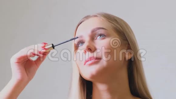 自信快乐的年轻女子拿着睫毛膏涂在睫毛上准备早上准备好微笑着美丽视频的预览图