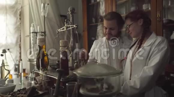 微笑的白种人男女看着透明液体的古瓶的肖像两名药剂师发现视频的预览图