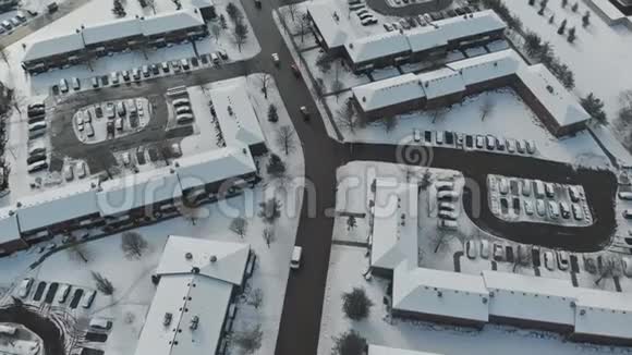 当房屋和街道被雪覆盖时无人机低空飞过小镇视频的预览图