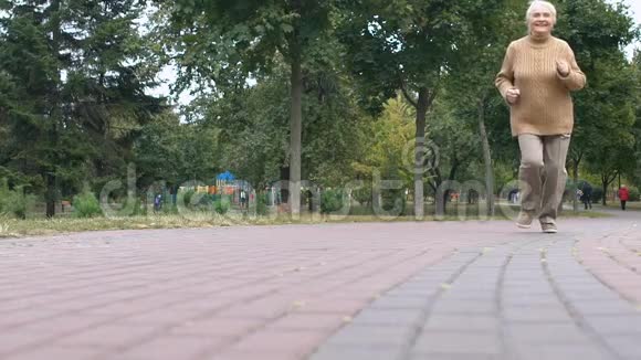快乐的老太太在公园里慢跑户外健康活动晚年幸福视频的预览图
