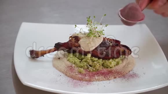 厨师用烤鸟腿装饰香料鸭子手的特写动作视频的预览图