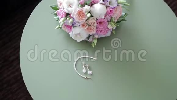 绿桌上的耳环手腕手镯新娘花束视频的预览图